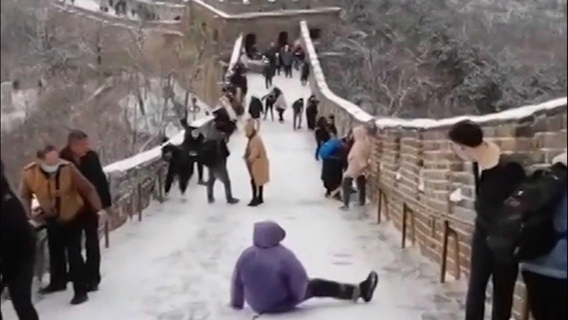 Tourists struggled to walk along the Great Wall of China on Nov. 21, after a winter storm coated the historic attraction in snow and ice.