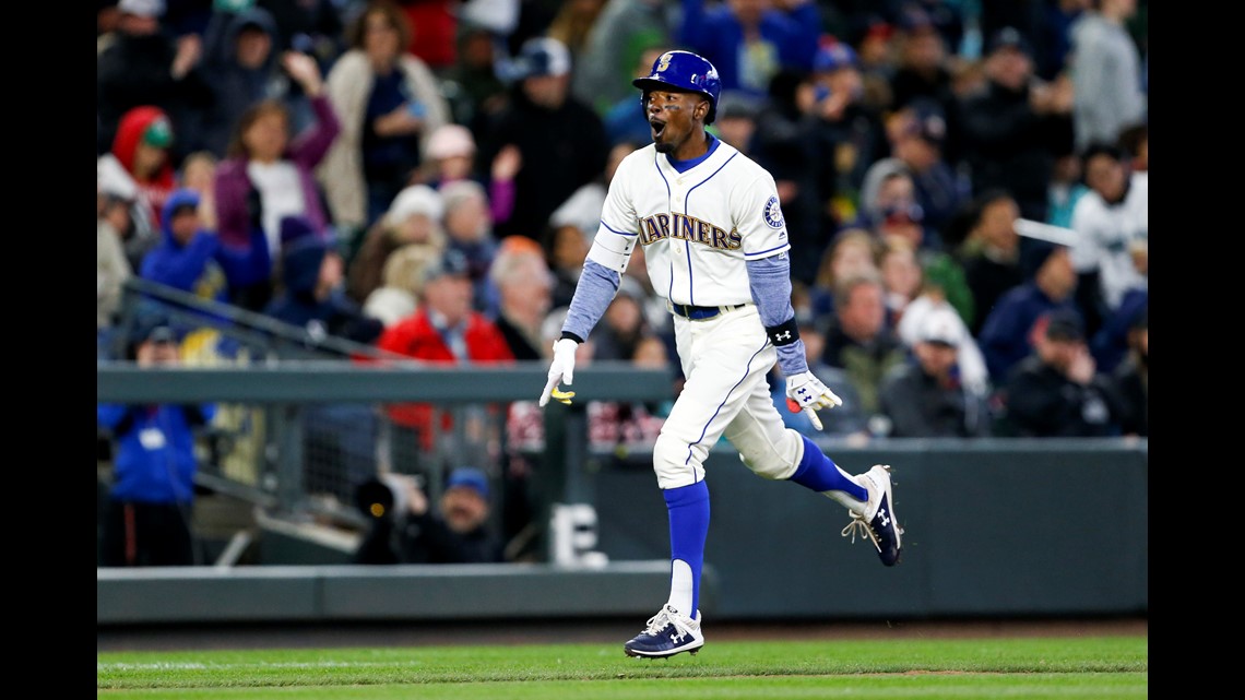 Seattle Mariners' Dee Gordon celebrates in the dugout after a home