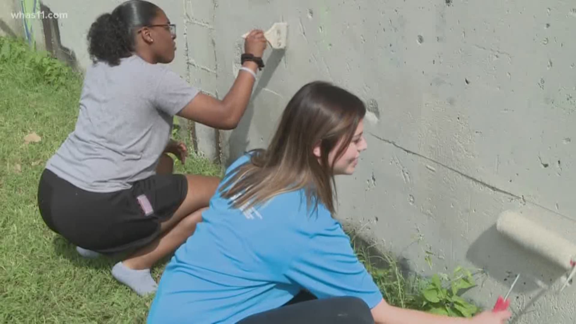 Students gather to clean up litter and paint over graffiti, not too far from the University of Louisville campus.