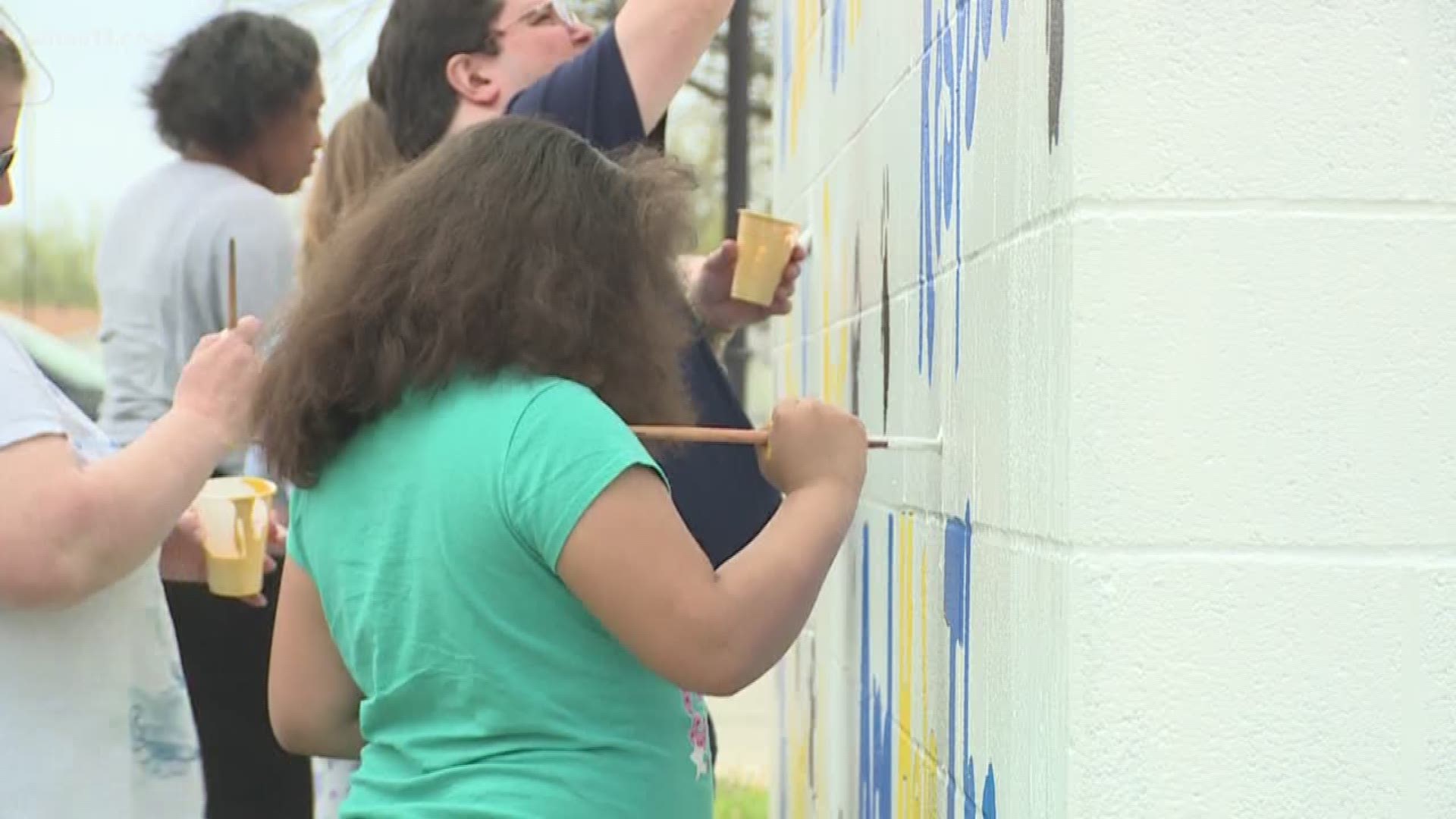 Months after an elementary school was vandalized with spray paint... teachers... parents.. and students... and even volunteers from Spalding University... spent their afternoon at Blue Lick Elementary School... repainting a mural hit by the vandals.