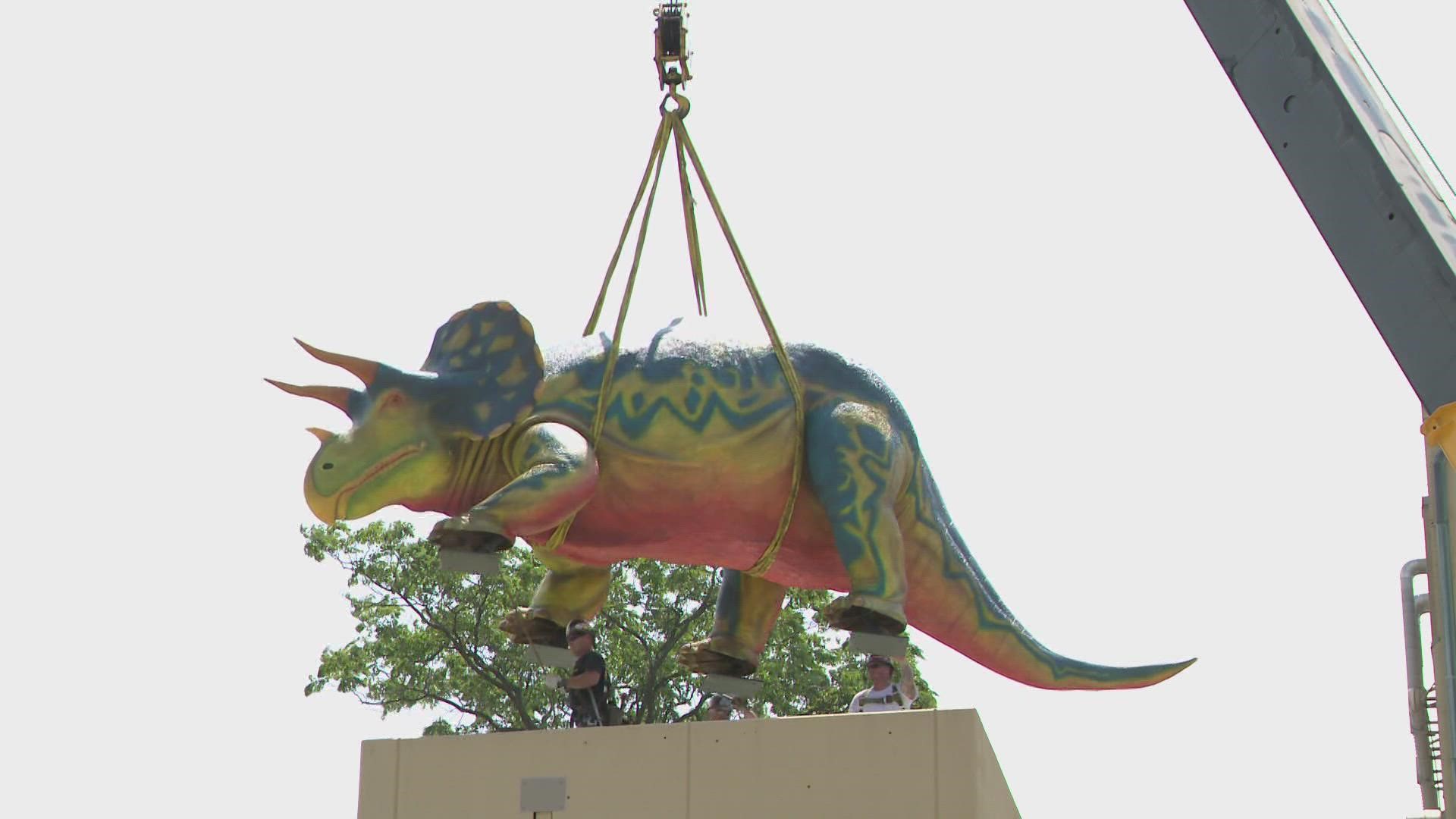 The dinosaur now sits on top of the parking lot elevator to the pedway over West Washington Street.