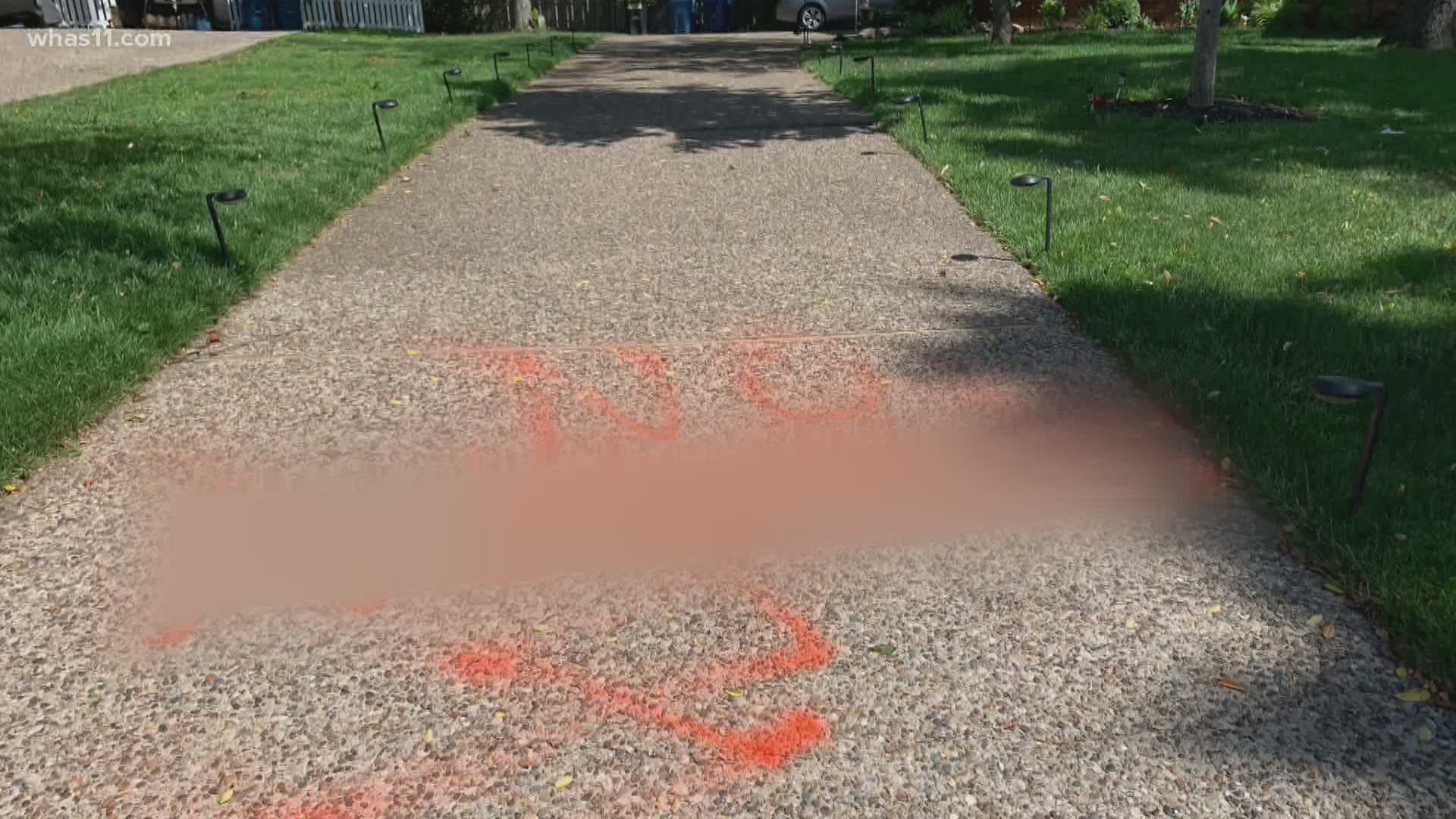 A woman is now facing charges after racial slurs were spray painted on the driveways of two homes in Lake Forest.