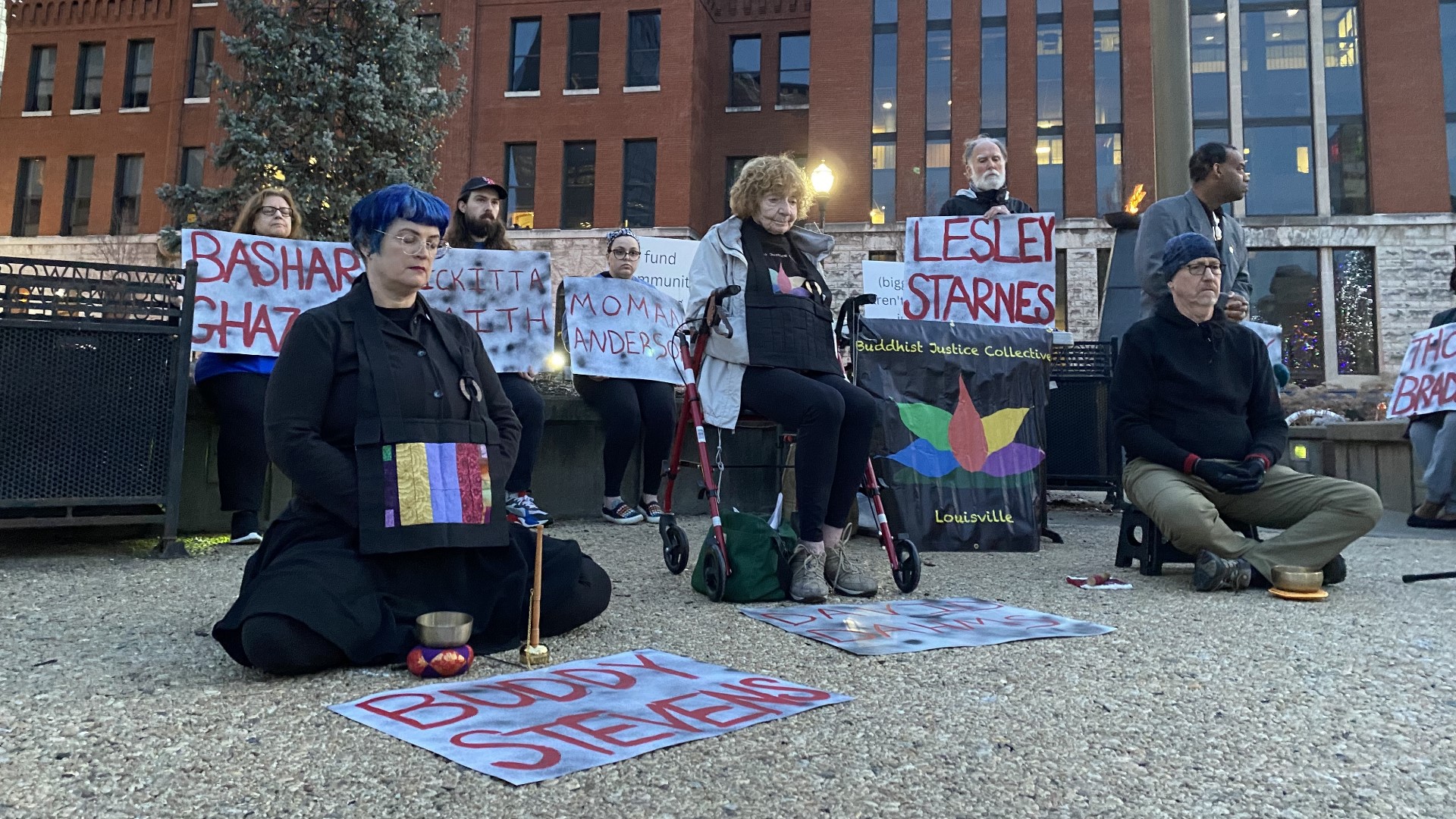 Activists marched around the Louisville jail Tuesday, holding signs with the names of the 13 people who have died in custody since 2021.