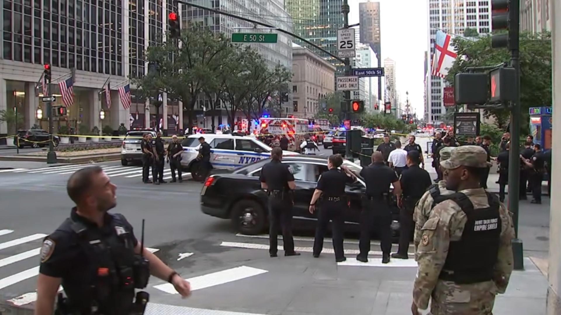 A man wielding a long gun shot and killed four people, including an off-duty police officer working security in Midtown Manhattan.