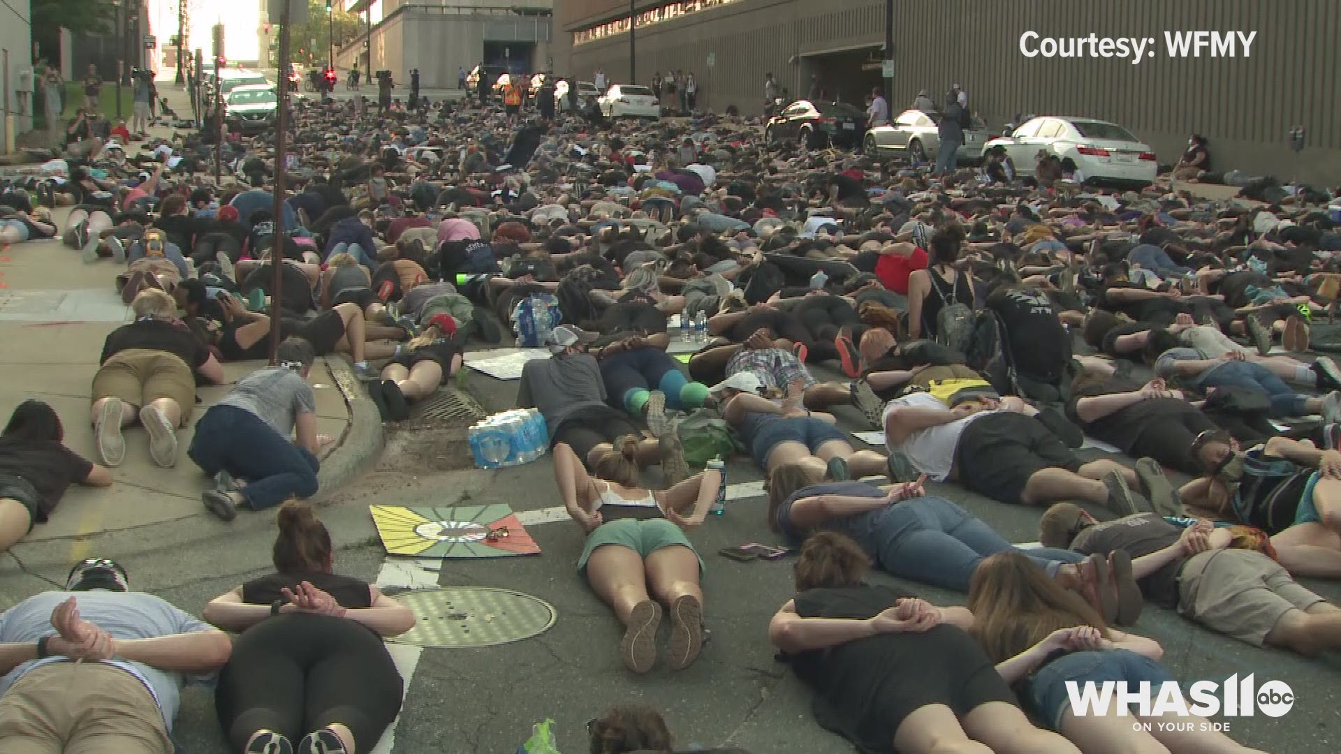 Hundreds of NC protesters remember George Floyd by lying in street with hands behind back.